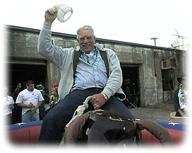 Guest riding mechanical bull waving hat