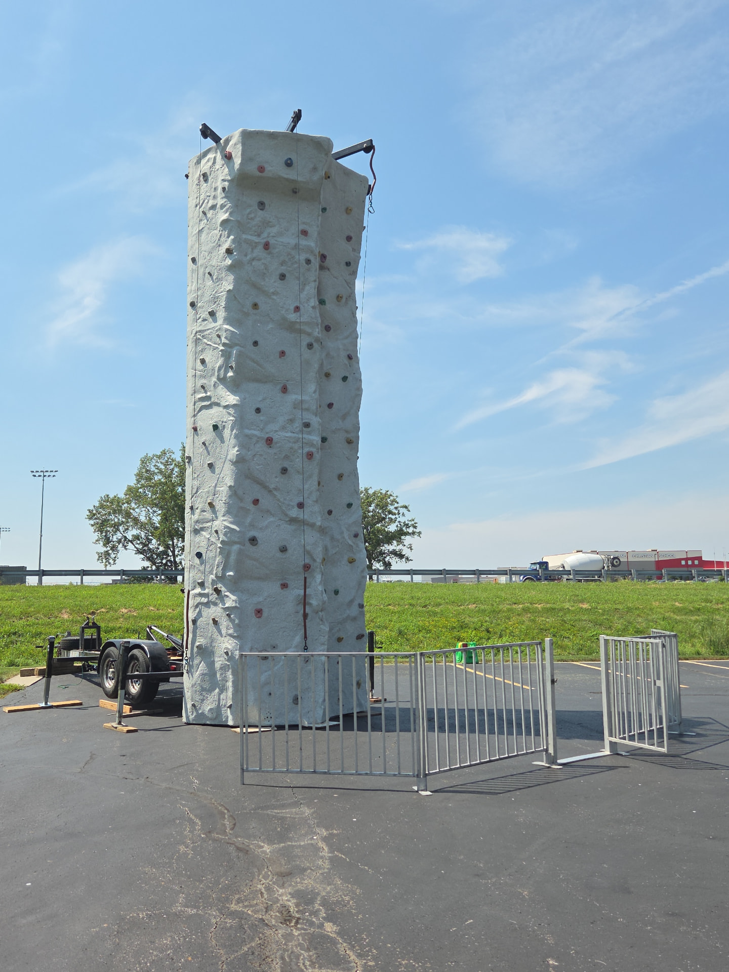 Mobile rock climbing wall with safety fencing at a Kansas City event